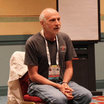 A photo showing Kenneth "Ken" Klingenstein sitting on a chair and participating in discussion during the 2018 Internet2 Technology Exchange in Orlando, Florida. 