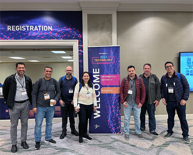 Photo of attendees standing in front of the TechEX22 registration booth.